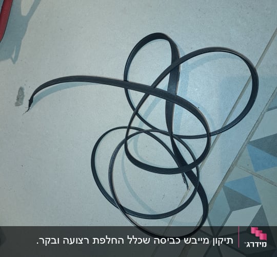 חגורת גומי שחורה מונחת על רצפה אפורה
